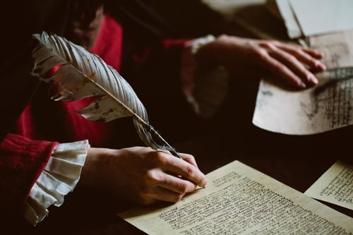 sulkakynä kädessä ja papereita pöydällä.