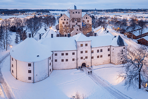 Turku castle in the winter. A tall stone building with a tower.