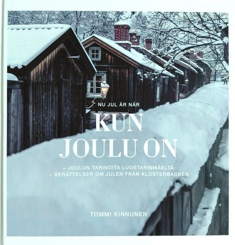 En snötäckt gränd på Klosterbacken med mörka hus.